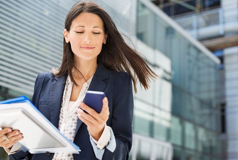a woman walking and looking at her phone